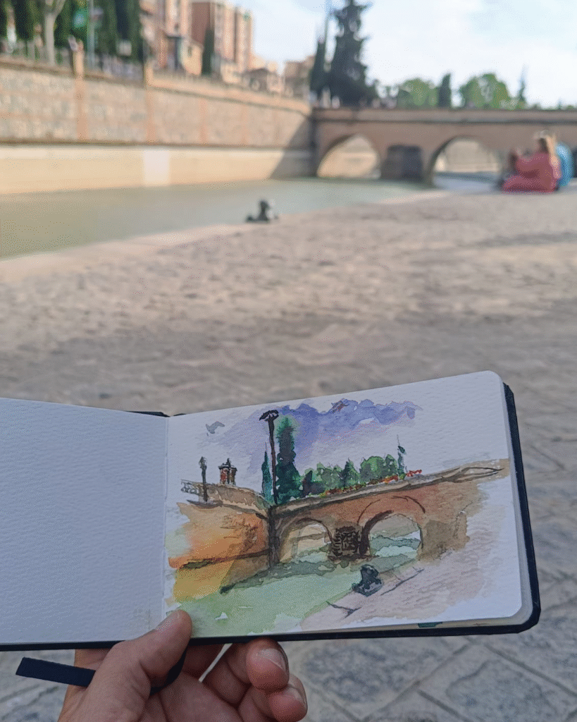 Yohan Pixone pintando con acuarela al aire libre como parte de su proceso artístico de observación del espacio.