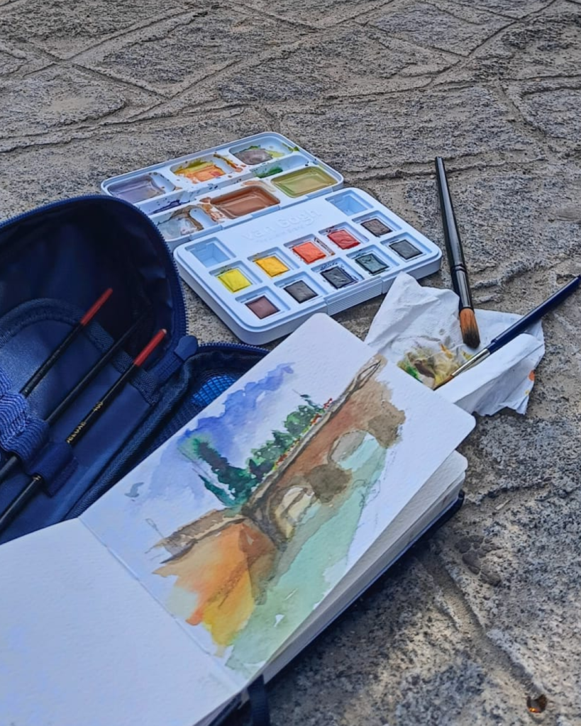 Yohan Pixone pintando con acuarela al aire libre como parte de su proceso artístico de observación del espacio.
