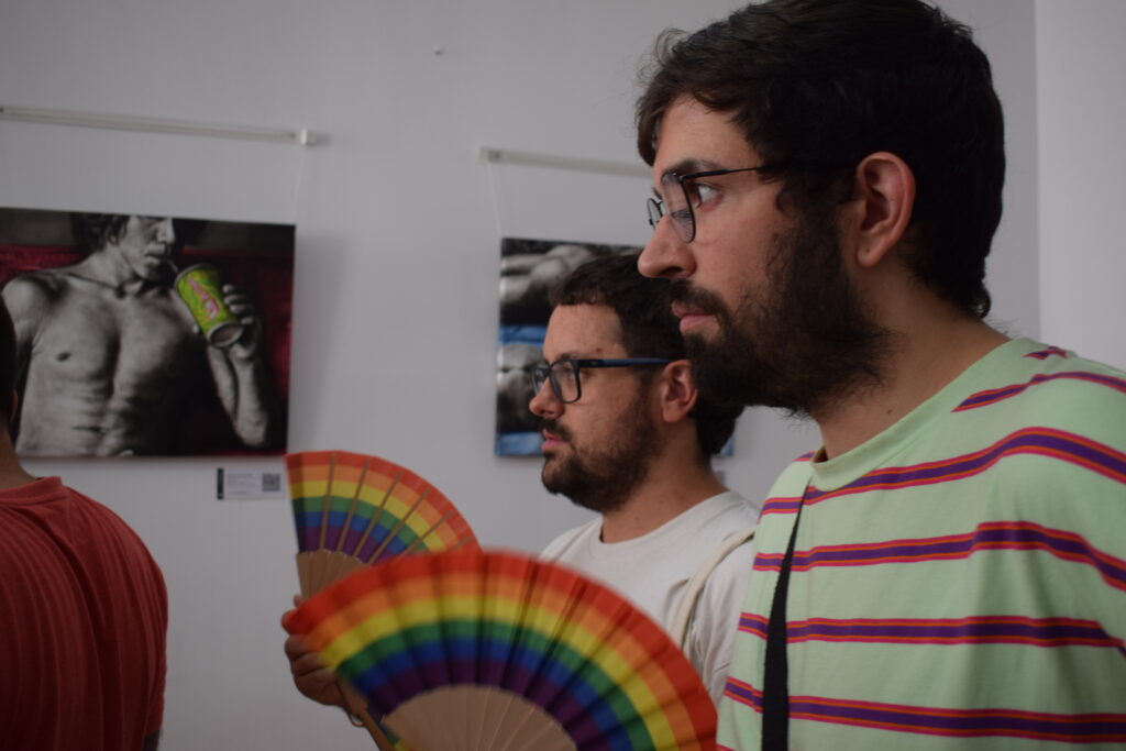 Visitantes conversando frente a las pinturas de Cuerpos en suspensión de Yohan Pixone.