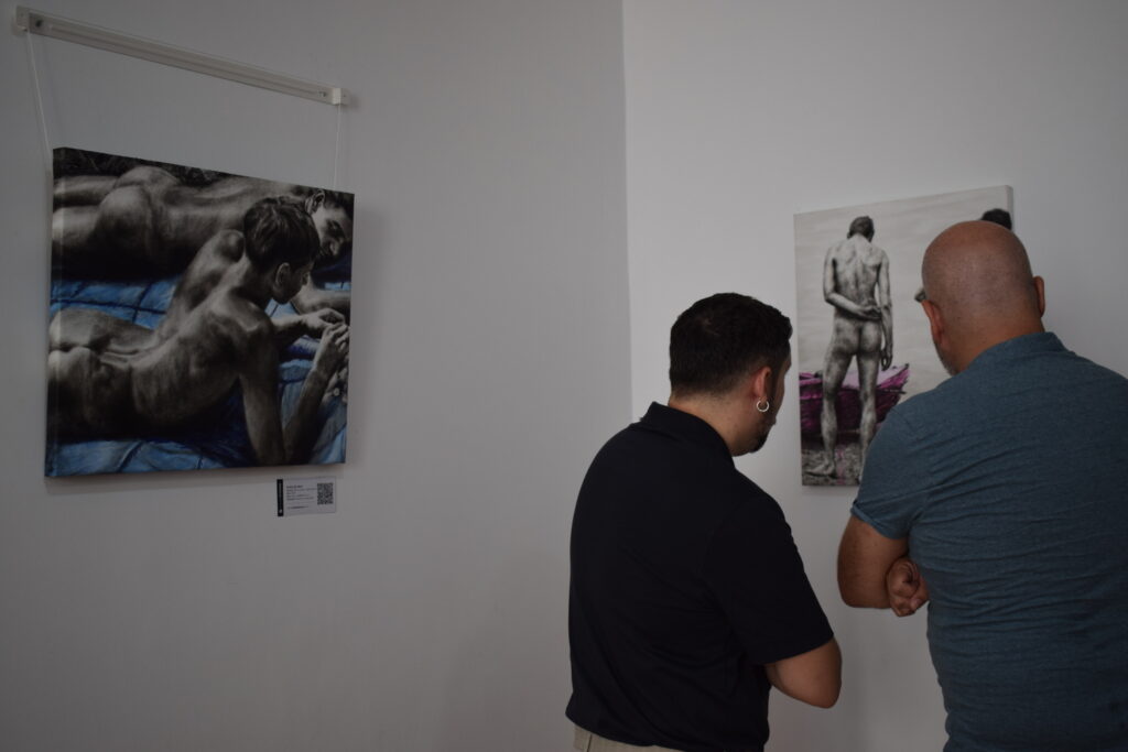 Personas observando las obras de la exposición Cuerpos en suspensión en Casa Granada.