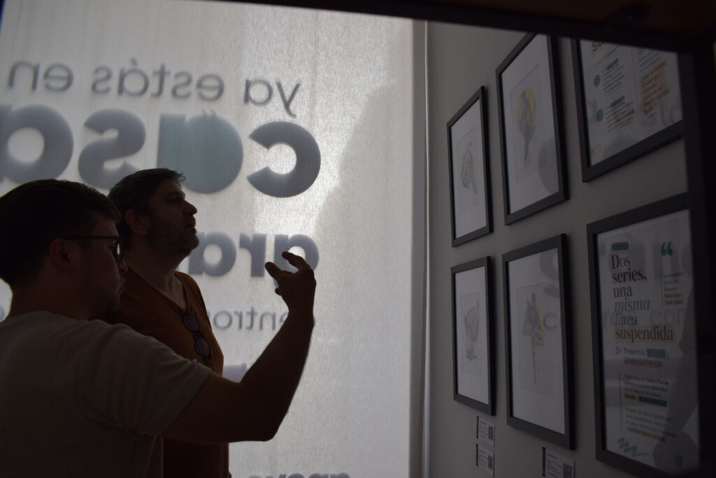 Visitantes conversando frente a las pinturas de Cuerpos en suspensión de Yohan Pixone.