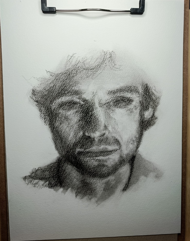 Dibujo de rostro masculino de Yohan Pixone, realizado en grafito y carboncillo, explorando la mirada contenida y la construcción por masas.
