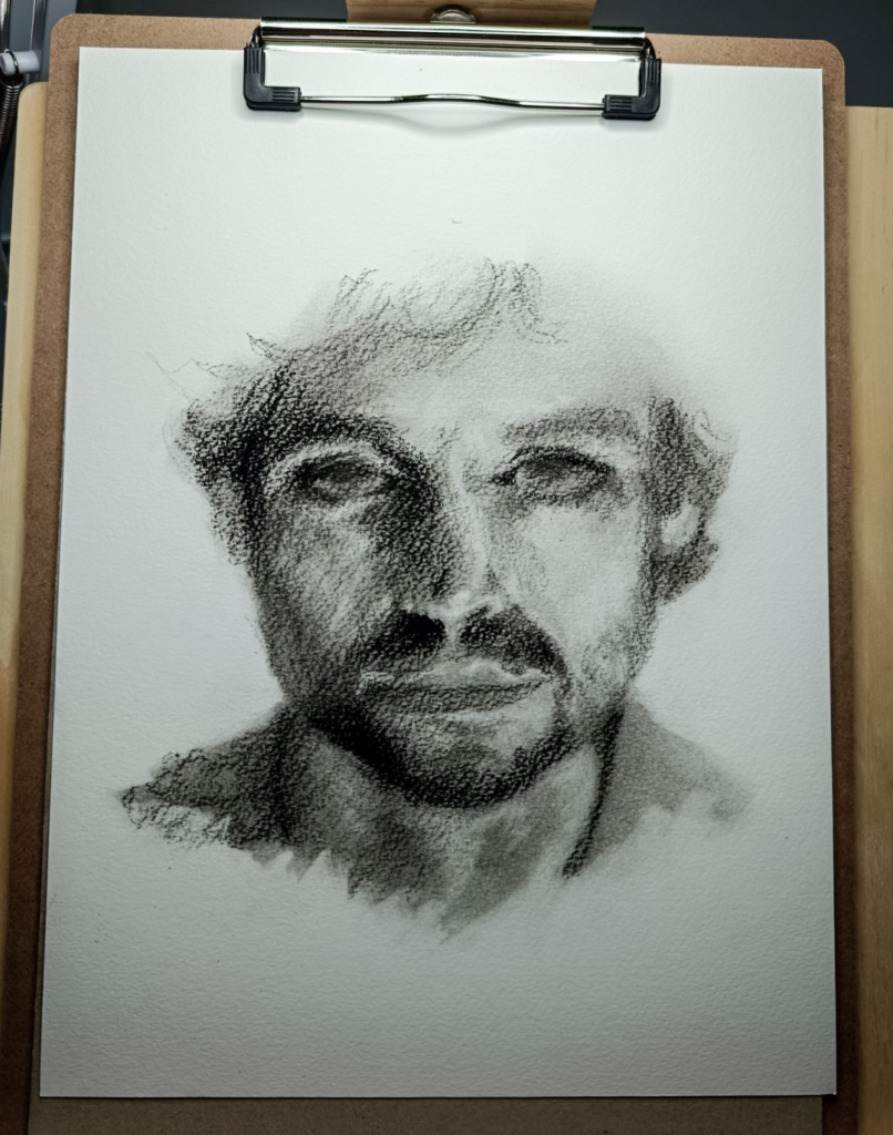 Dibujo de rostro masculino de Yohan Pixone, realizado en grafito y carboncillo, explorando la mirada contenida y la construcción por masas.