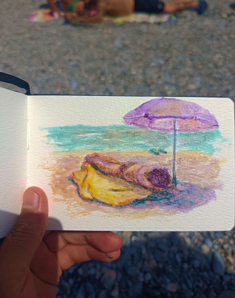 Cuaderno de acuarela de Yohan Pixone en la playa de Almuñécar, con paleta de colores y goma arábiga.