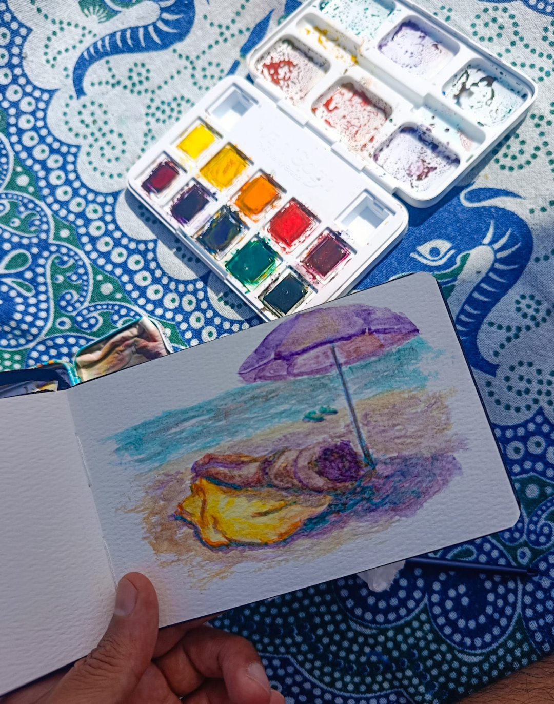 Cuaderno de acuarela de Yohan Pixone en la playa de Almuñécar, con paleta de colores y goma arábiga.