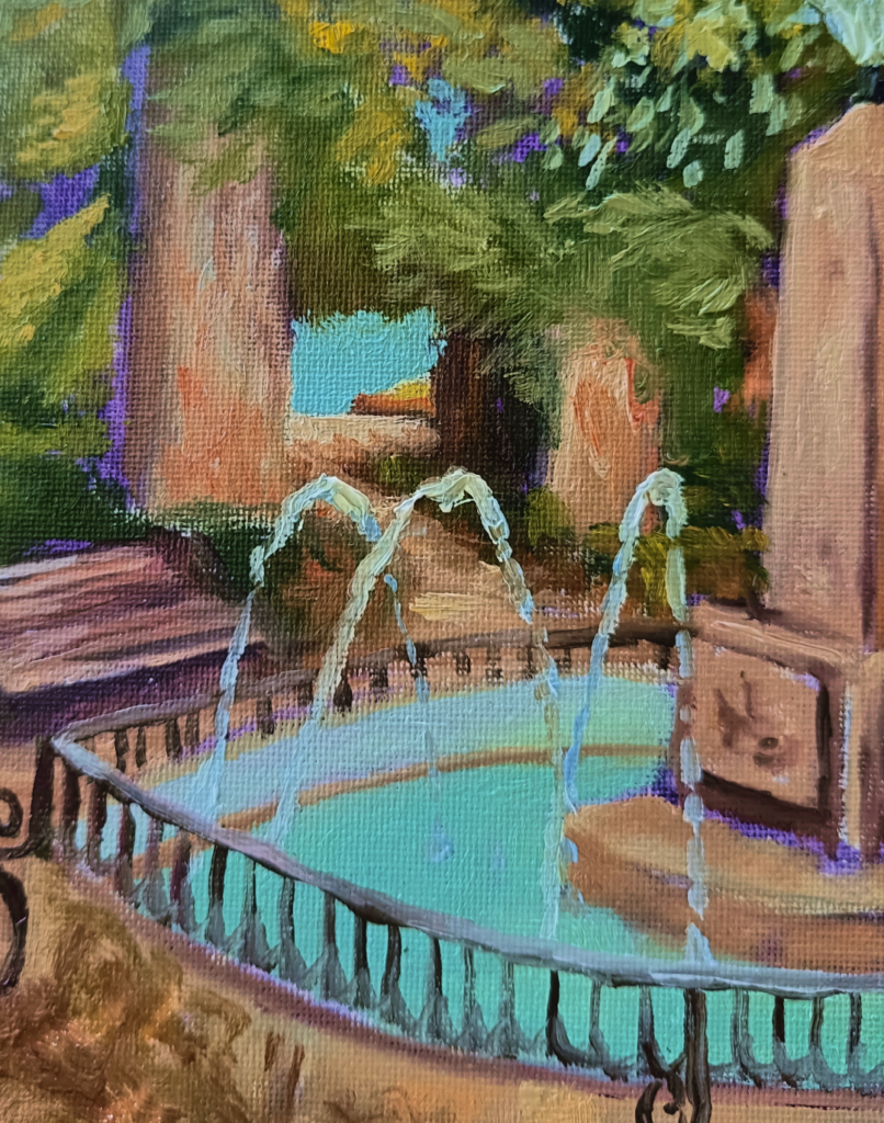 Caballete y materiales de pintura de Yohan Pixone bajo los árboles, junto a una fuente del centro de Granada.