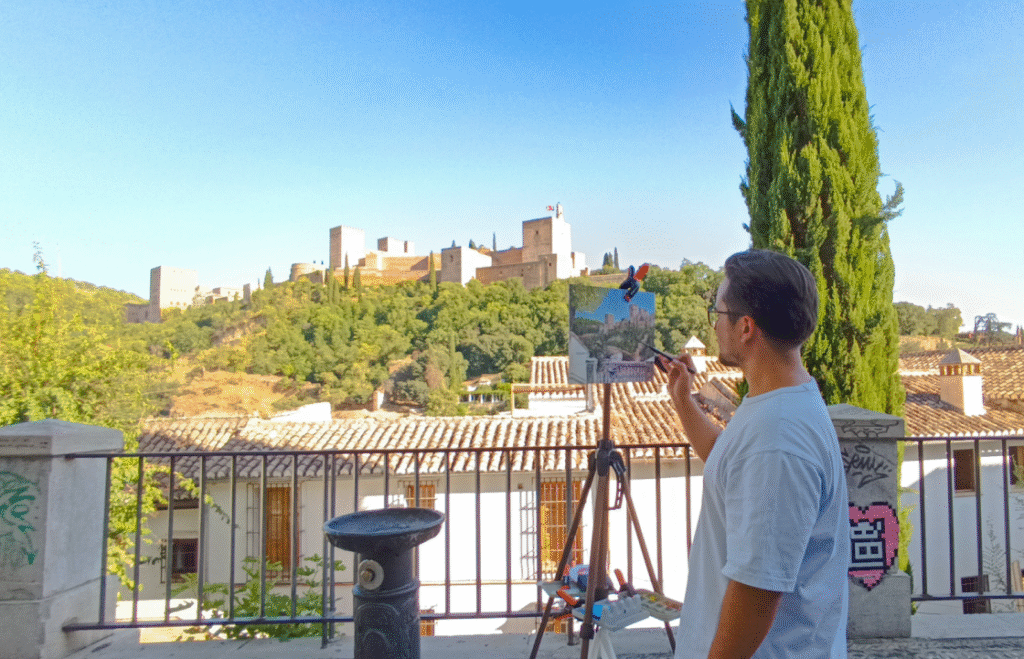 Yohan Pixone pintando plein air frente a la Alhambra de Granada durante una sesión de Laboratorio de Campo
